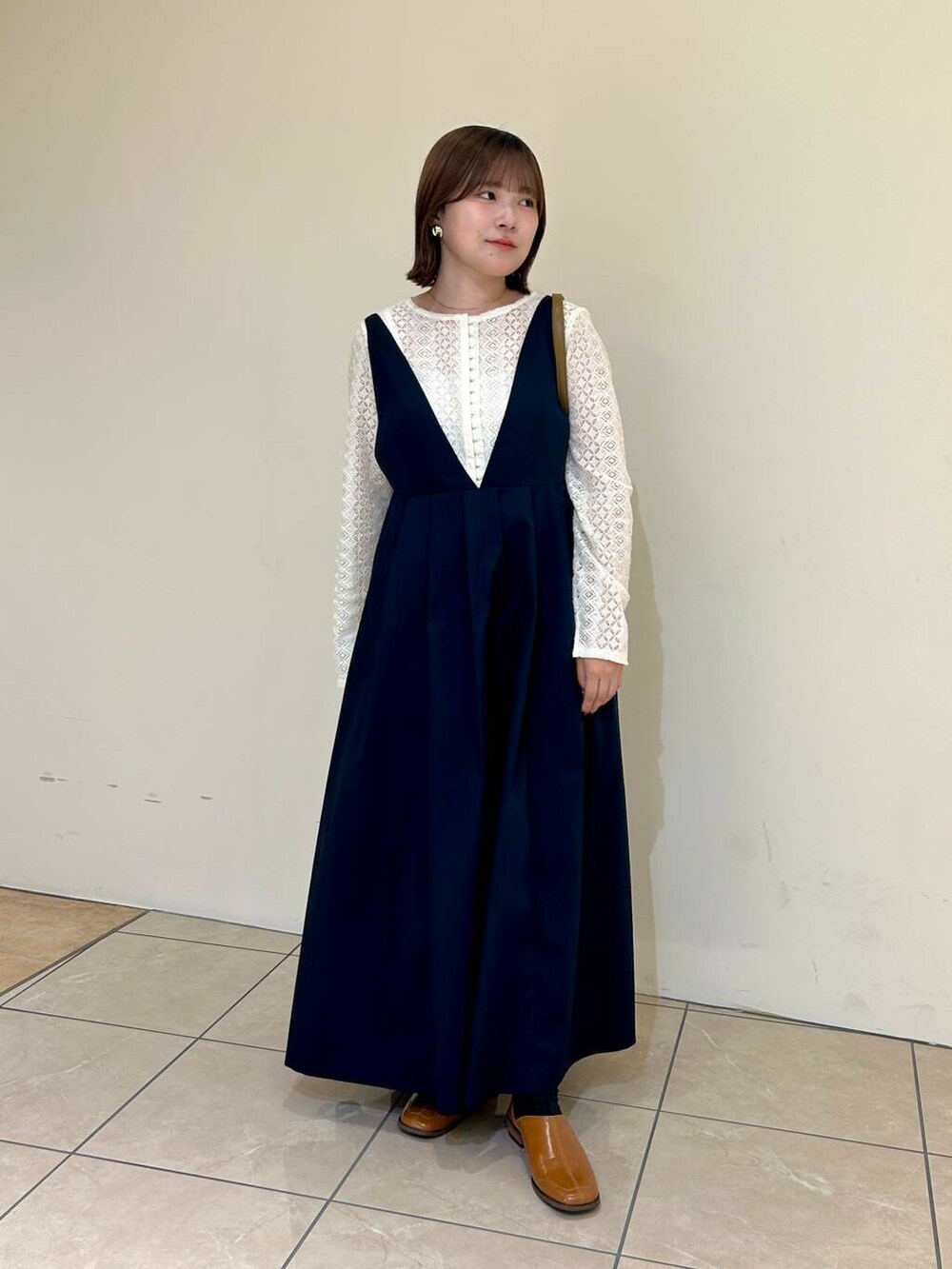 グリーン系のボストンバッグ、ブルー系のワンピース、イエロー系のその他シューズを着用したレディースの秋コーディネートの3枚目の写真