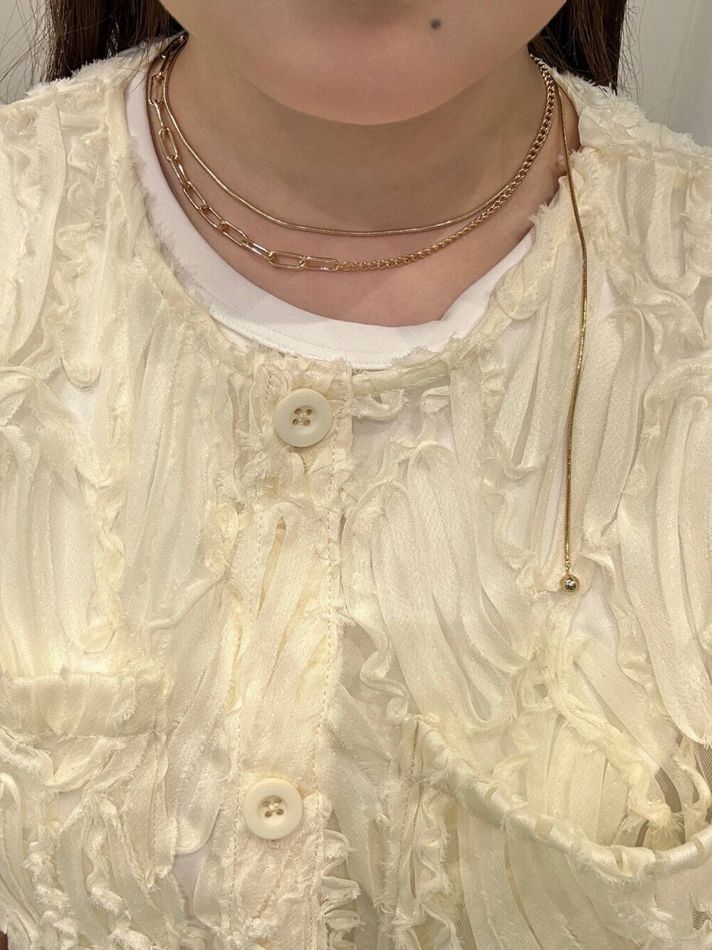 ブラウン系のキャップ、ゴールド系のネックレス、ゴールド系のリングを着用したレディースの夏コーディネートの2枚目の写真