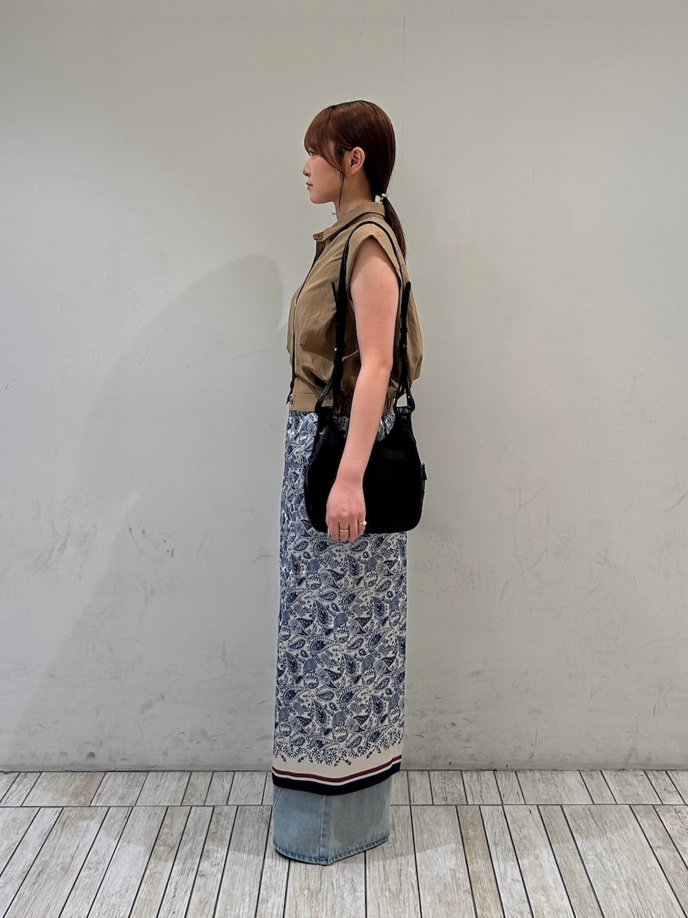 グリーン系のセットアップ、ブルー系のデニムパンツ、ブラック系のショルダーバッグを着用したレディースの夏コーディネートの3枚目の写真