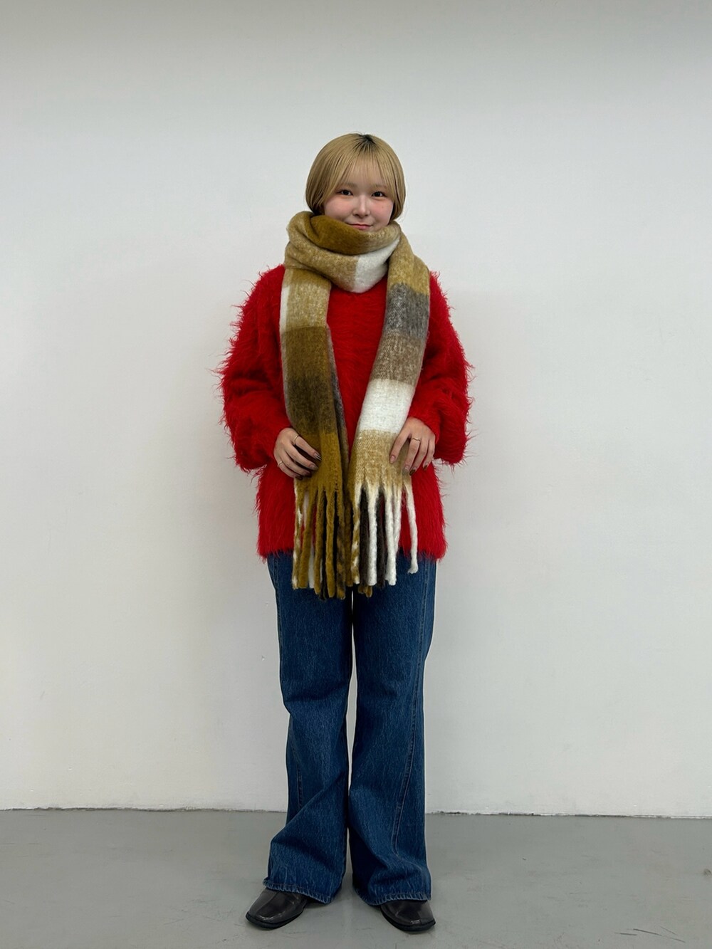 レッド系のニット/セーター、ブルー系のデニムパンツ、グレー系のその他シューズを着用したレディースの秋コーディネートの2枚目の写真