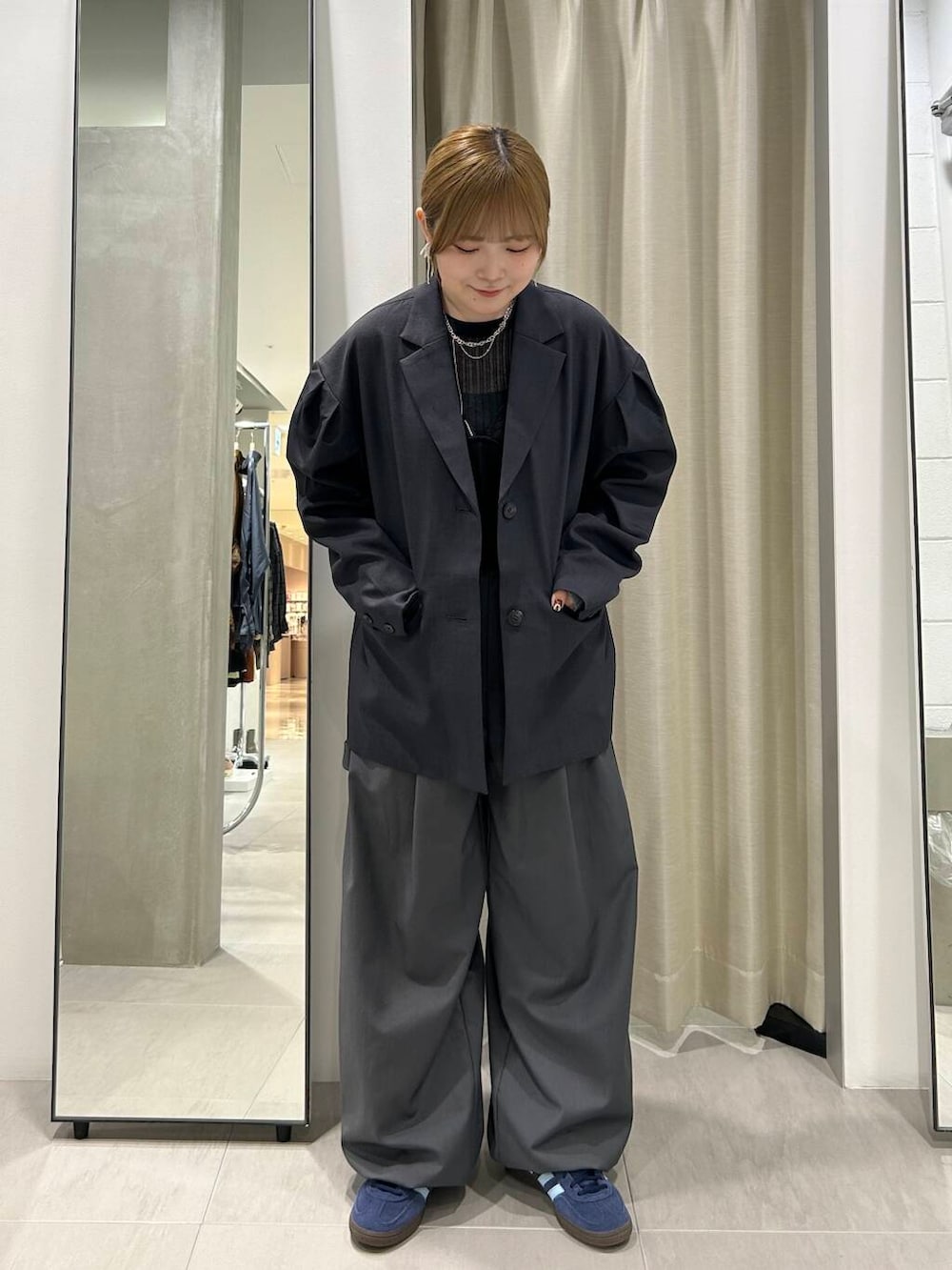 グレー系のスラックス、ブラック系のその他トップス、グレー系のその他アウターを着用したレディースの秋コーディネートの5枚目の写真