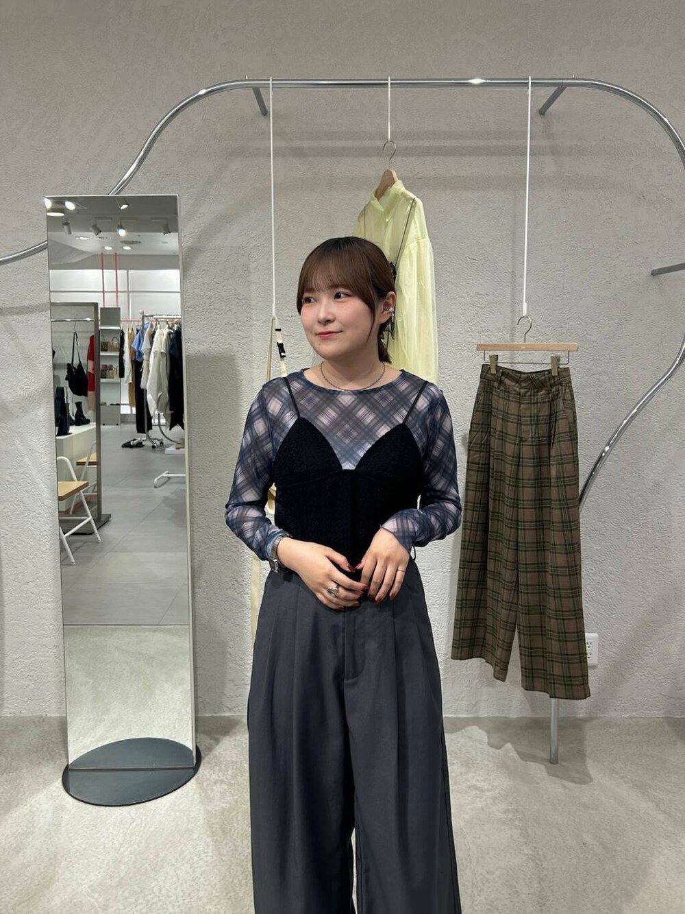 ブラック系のスニーカー、グレー系のスラックス、ブラック系のその他トップスを着用したレディースの秋コーディネートの3枚目の写真