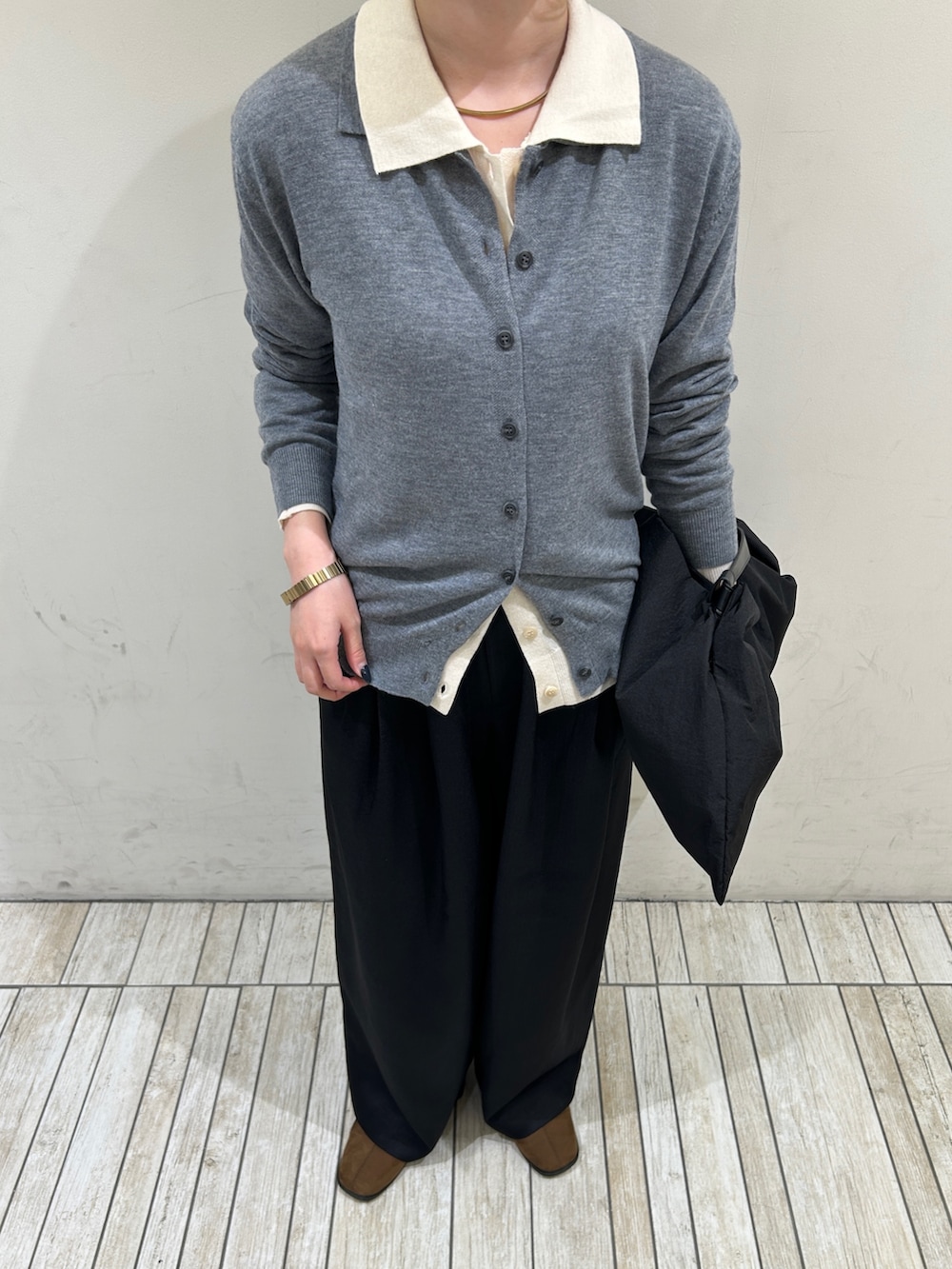 グレー系のカーディガン/ボレロ、ホワイト系のカーディガン/ボレロ、ブラック系のハンドバッグを着用したレディースの秋コーディネートの3枚目の写真