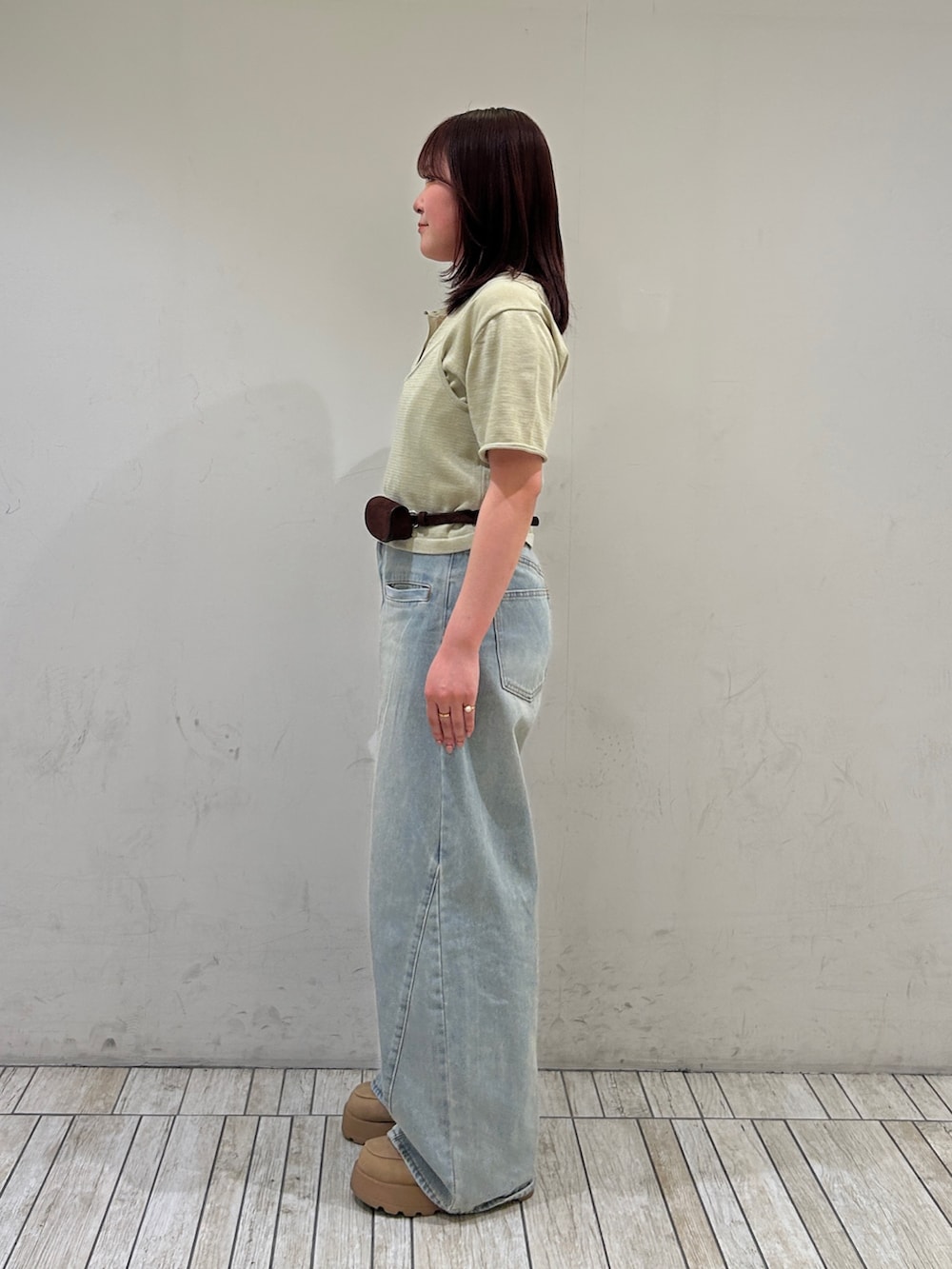 ブルー系のデニムパンツ、ベージュ系のカーディガン/ボレロ、ブラウン系のベルトを着用したレディースの春コーディネートの2枚目の写真