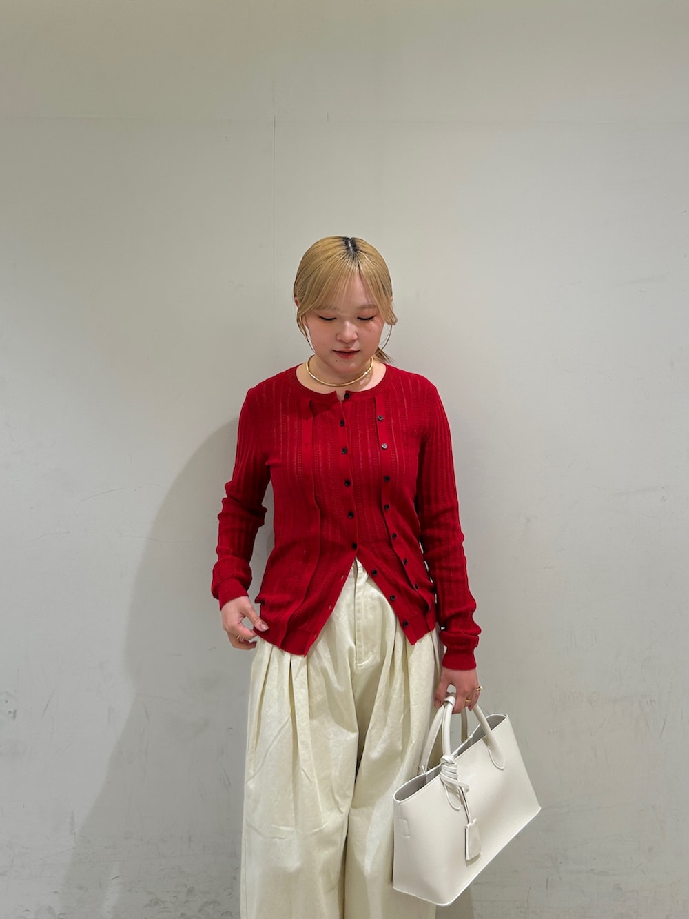 ホワイト系のその他パンツ、ホワイト系のハンドバッグ、レッド系のニット/セーターを着用したレディースの春コーディネートの5枚目の写真