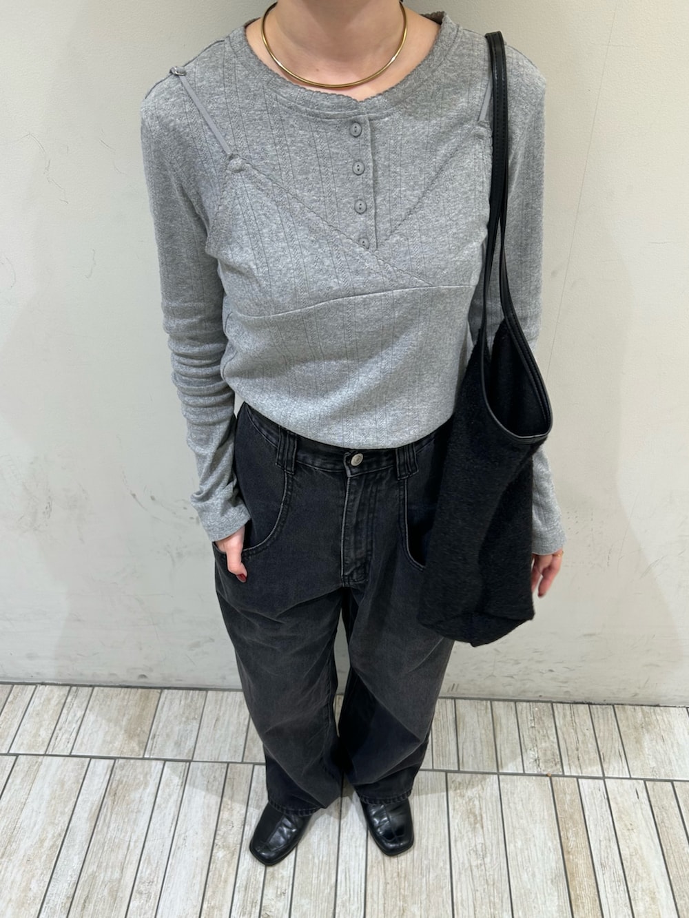 グレー系のTシャツ/カットソー、ブラック系のデニムパンツ、ブラック系のショルダーバッグを着用したレディースの秋コーディネートの3枚目の写真