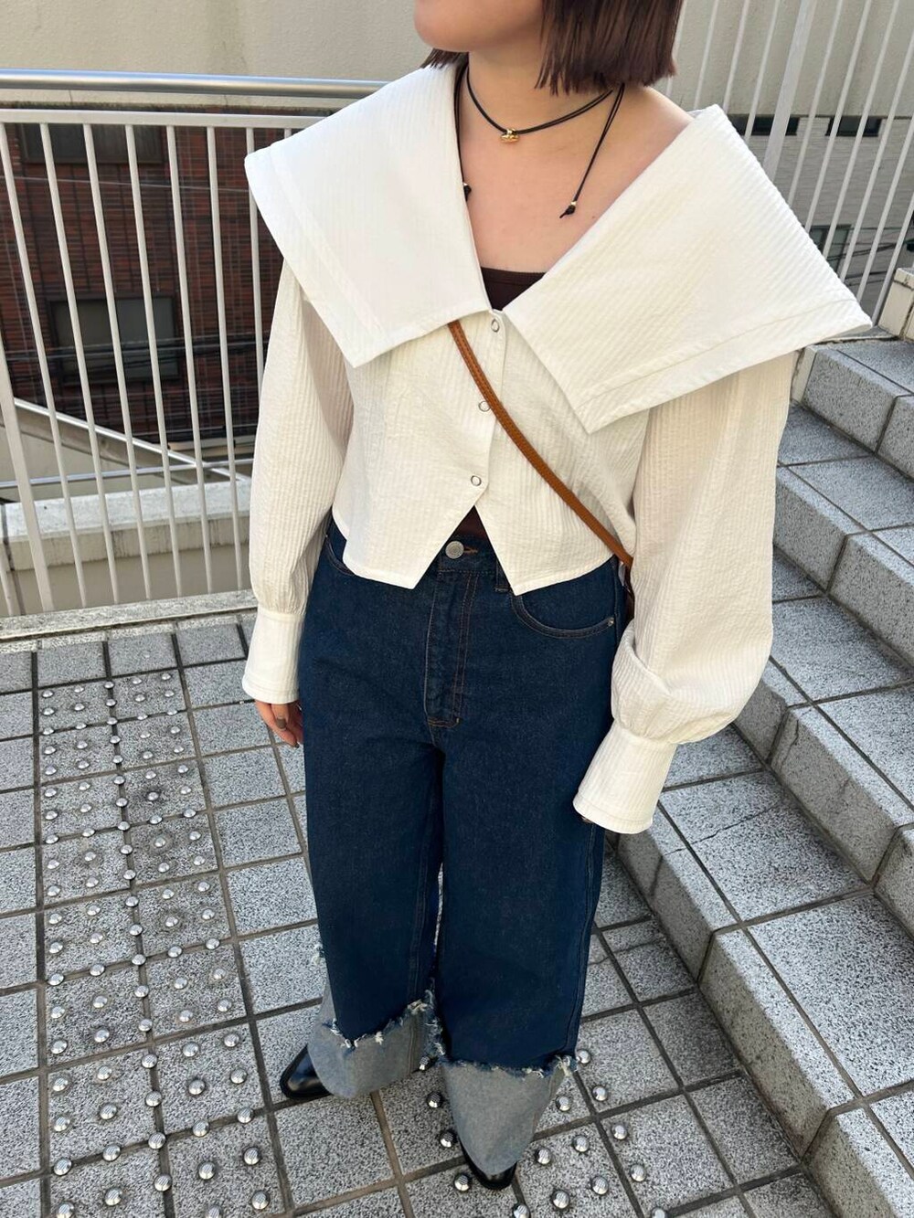 ブラウン系のキャミソール、イエロー系のハンドバッグ、ブラック系のローファーを着用したレディースの冬コーディネートの8枚目の写真
