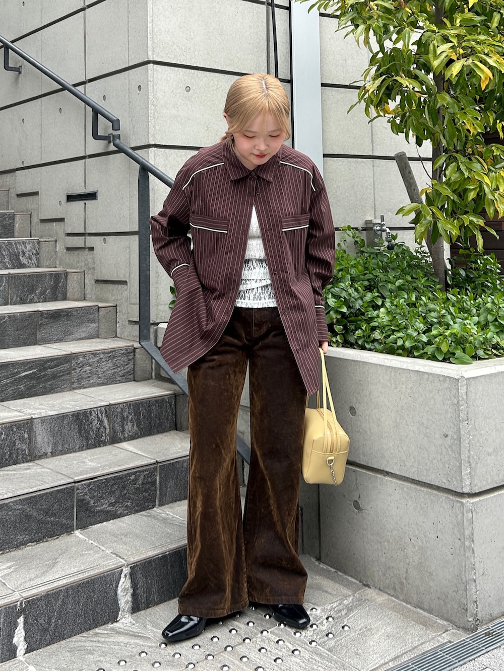 ブラウン系のシャツ/ブラウス、ホワイト系のTシャツ/カットソー、ブラウン系のデニムパンツを着用したレディースの春コーディネートの5枚目の写真