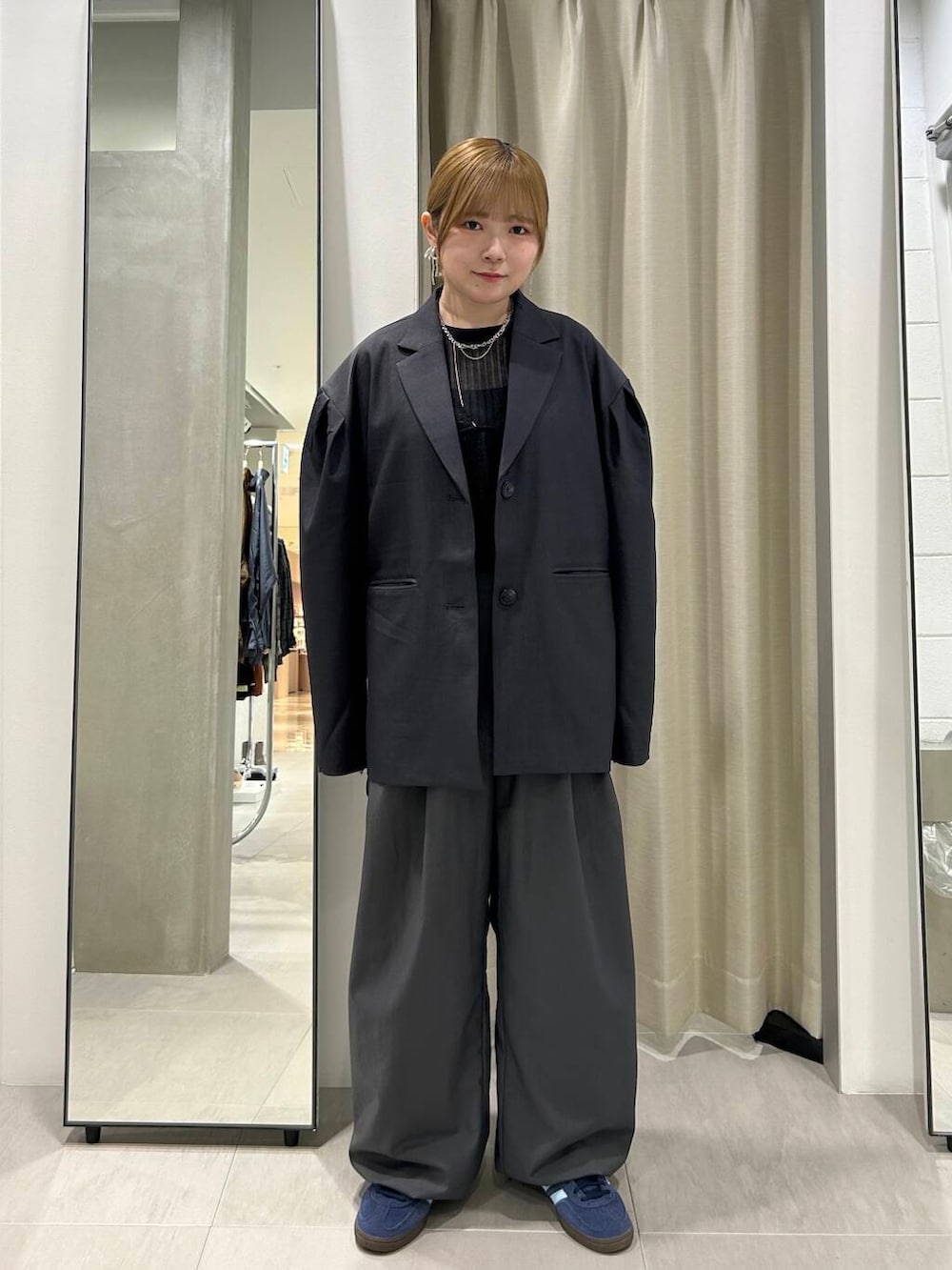 グレー系のスラックス、ブラック系のその他トップス、グレー系のその他アウターを着用したレディースの秋コーディネートの4枚目の写真