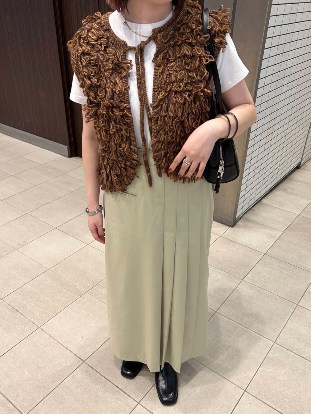 ホワイト系のTシャツ/カットソー、ブラウン系のベスト、ブラック系のボストンバッグを着用したレディースの夏コーディネートの7枚目の写真