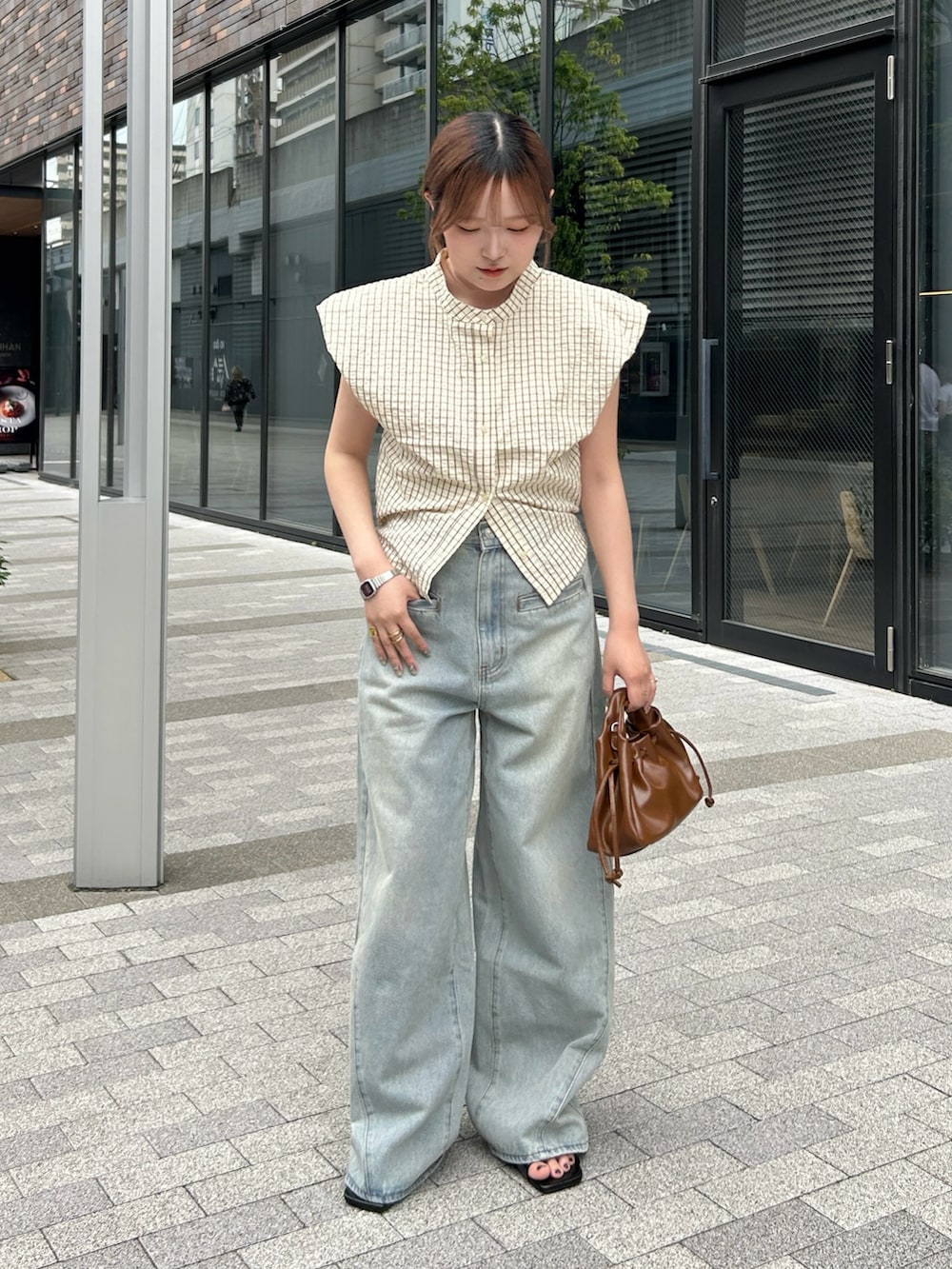 イエロー系のシャツ/ブラウス、ブルー系のデニムパンツ、ブラック系のサンダルを着用したレディースの夏コーディネートの2枚目の写真