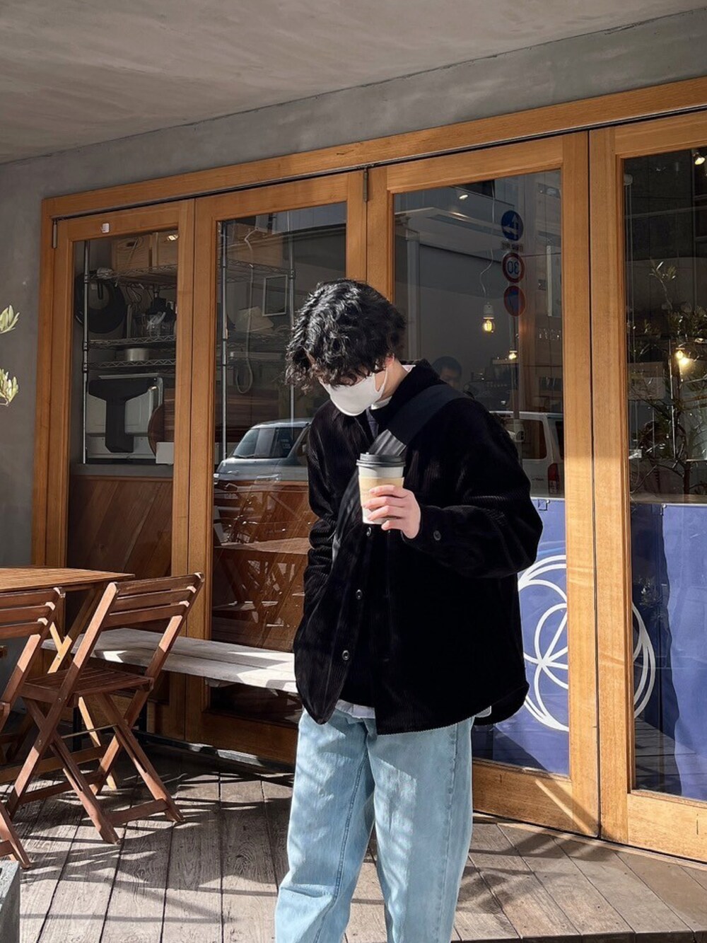 ブラック系のジャケット/アウター、ブラック系のニット/セーター、ブルー系のデニムパンツを着用したメンズの冬コーディネートの2枚目の写真