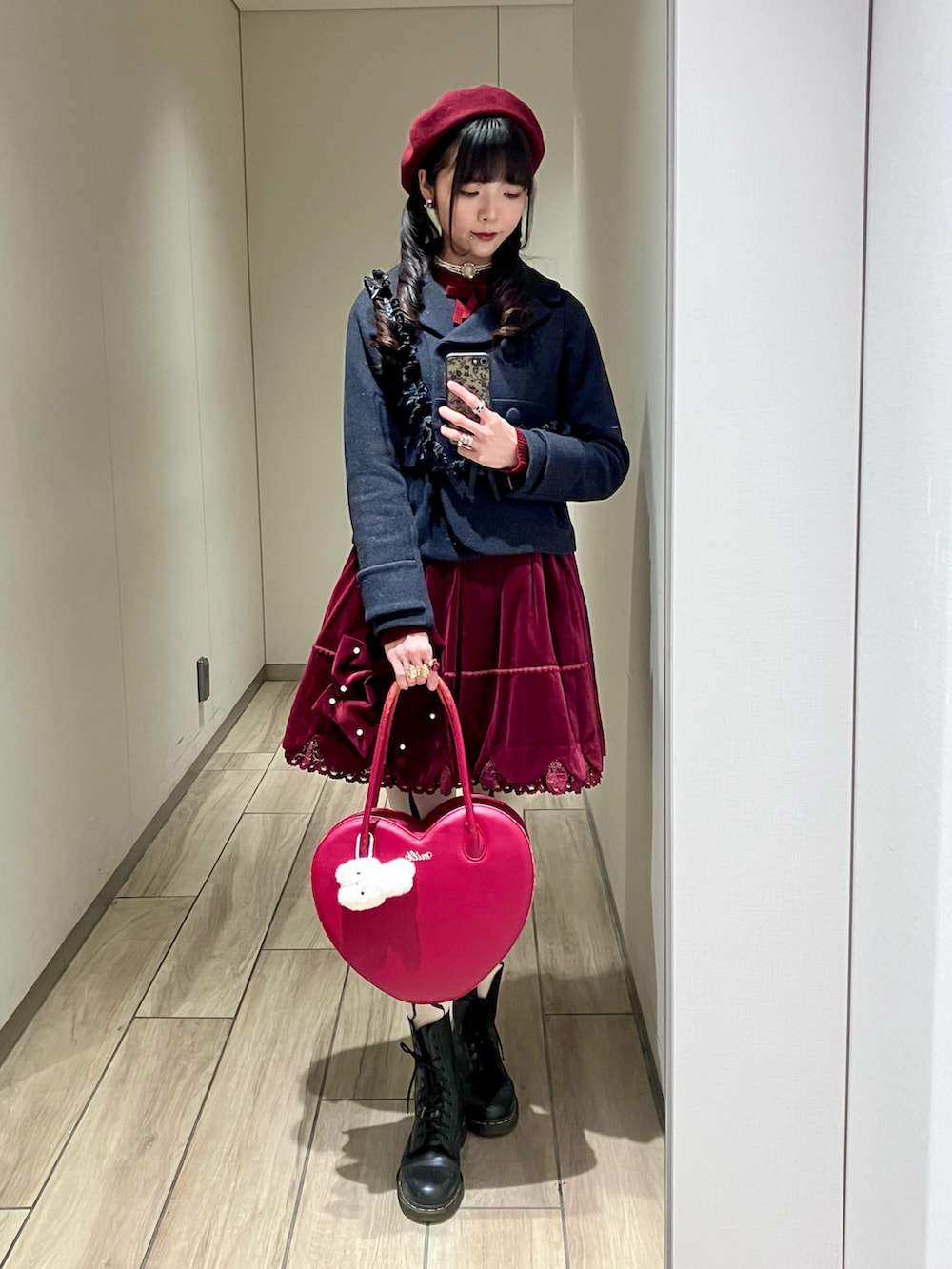 ブラック系のブーツ、その他のハンドバッグ、レッド系のニット/セーターを着用したレディースの冬コーディネートの2枚目の写真