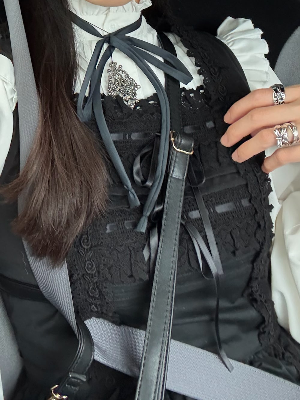 ブラック系のジャンパースカート、ブラック系のバックパック/リュック、ブラック系のパンプスを着用したレディースの春コーディネートの2枚目の写真