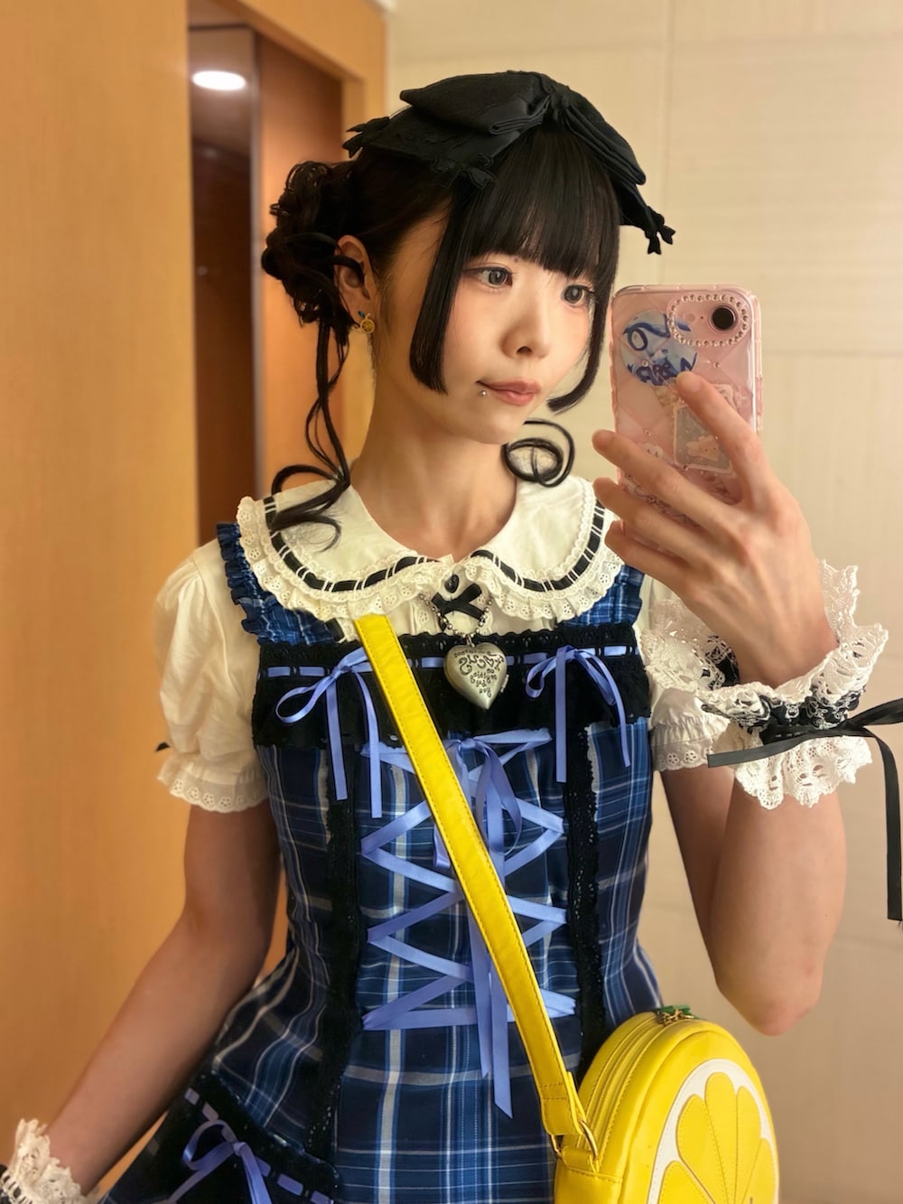 ブラック系のパンプス、イエロー系のショルダーバッグ、ブルー系のジャンパースカートを着用したレディースの夏コーディネートの2枚目の写真