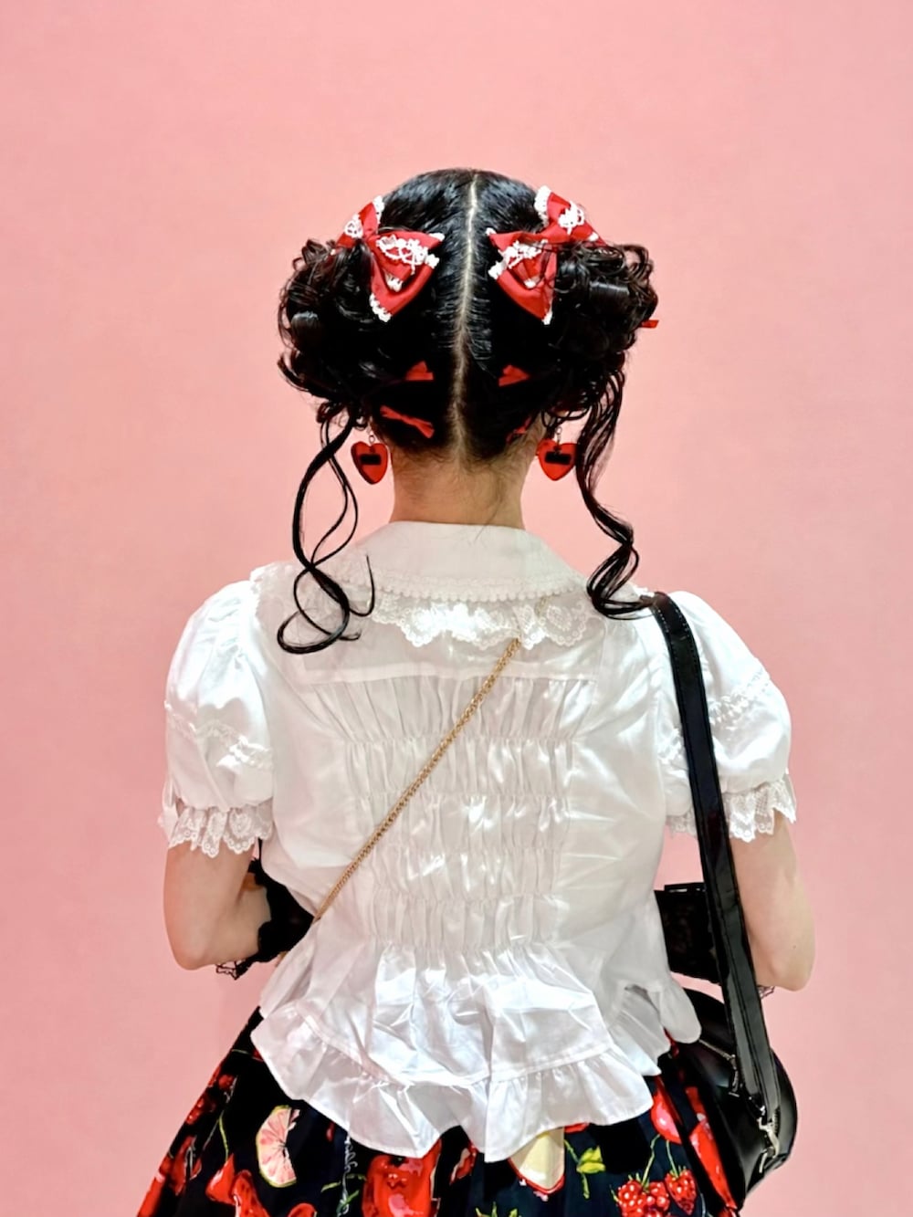 ブラック系のドレスシューズ、ブラック系のバックパック/リュック、ホワイト系のシャツ/ブラウスを着用したレディースの夏コーディネートの2枚目の写真
