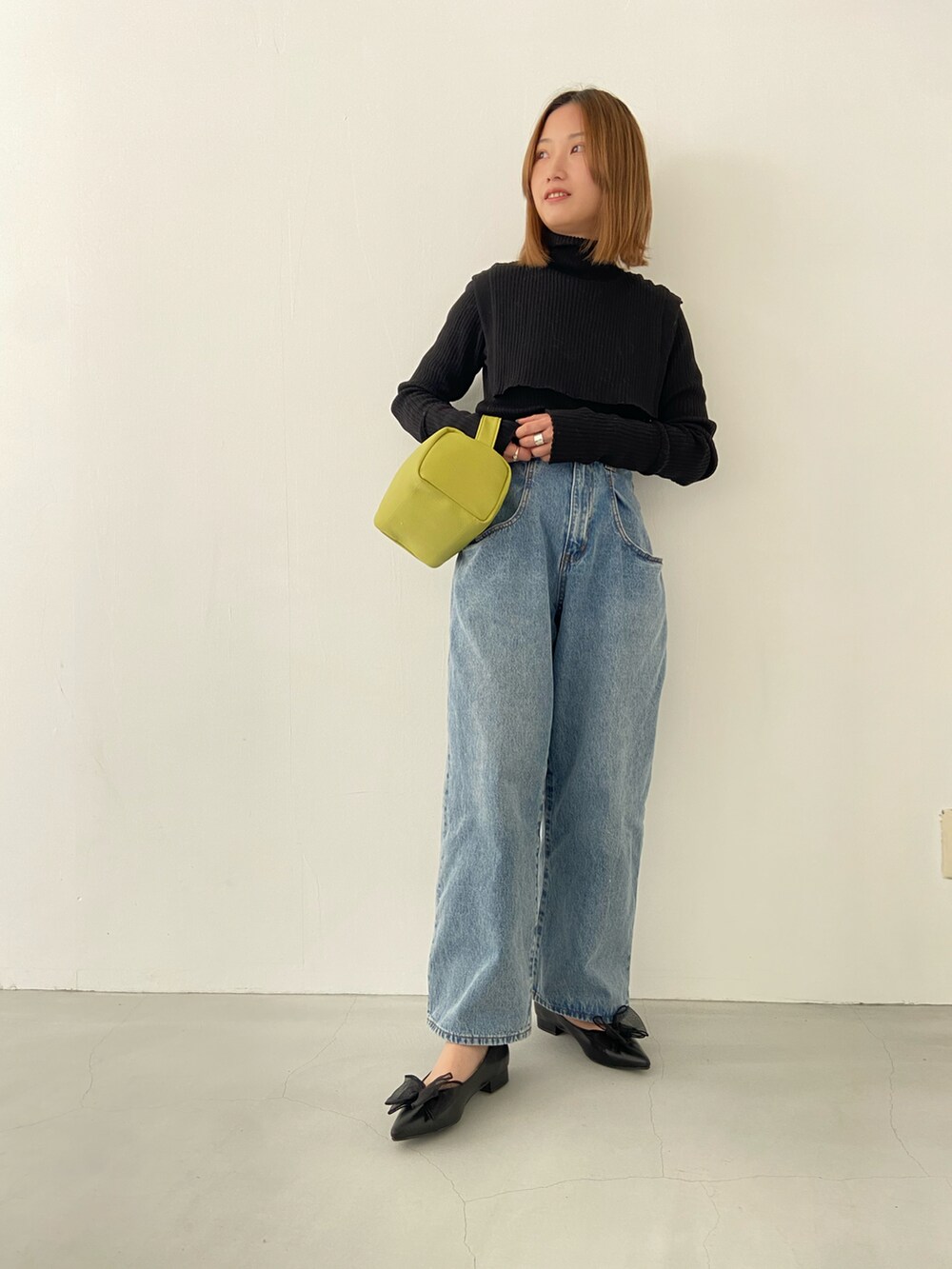 ブラック系のパンプスを着用したレディースの冬コーディネートの2枚目の写真