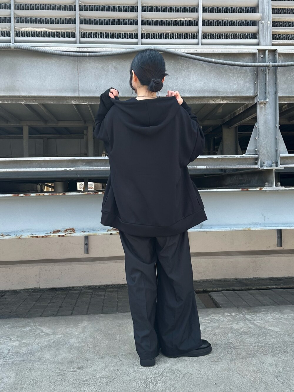 ブラック系のパーカーを着用したレディースの秋コーディネートの2枚目の写真