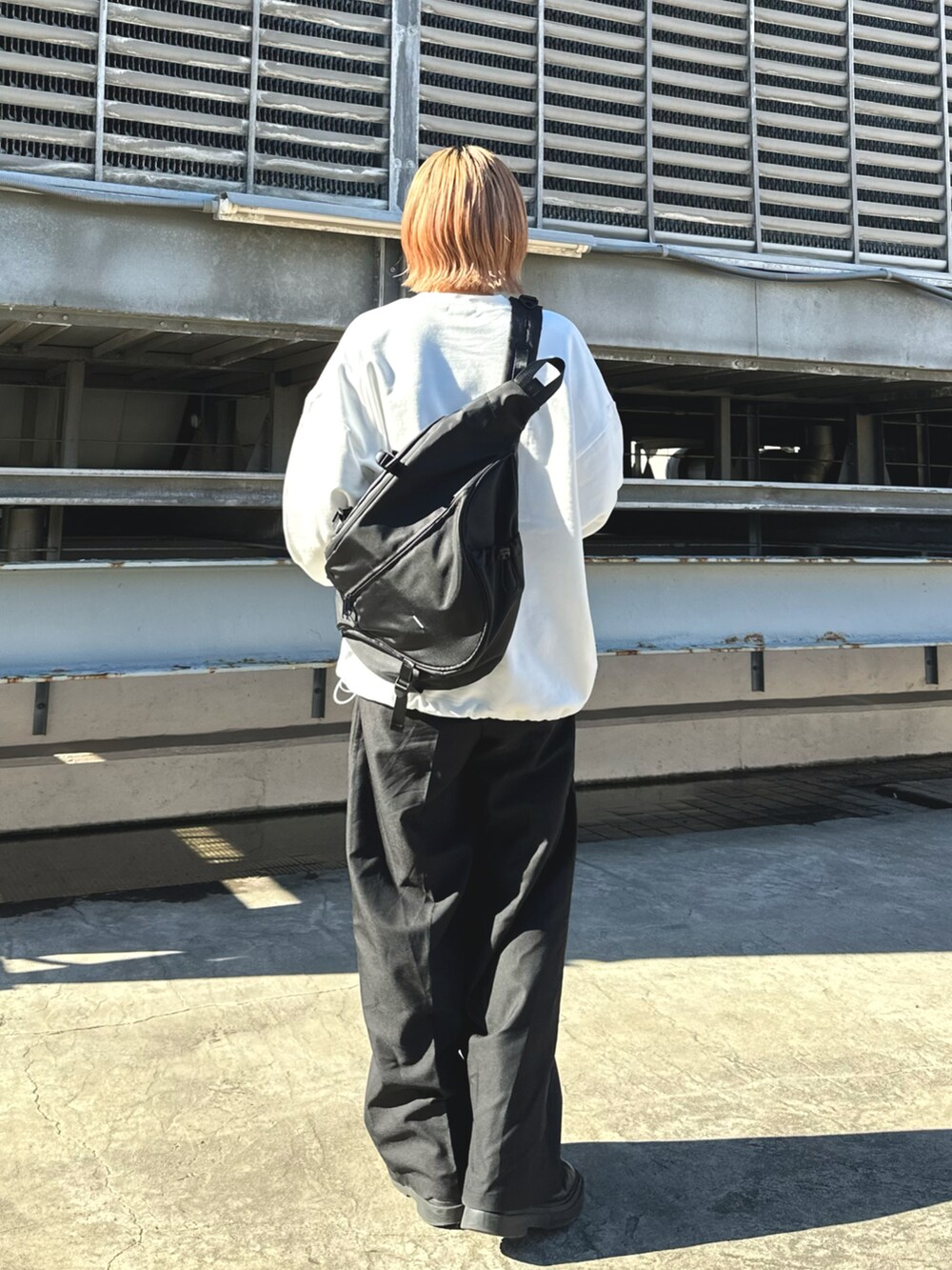 ホワイト系のスウェット、ブラック系のボディバッグ/ウエストポーチを着用したレディースの冬コーディネートの3枚目の写真