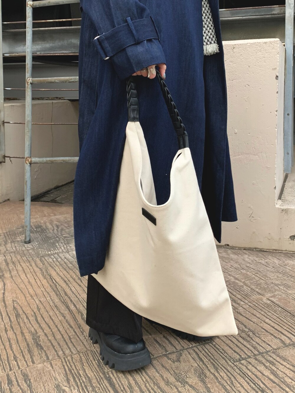 ブルー系のトレンチコート、ホワイト系のハンドバッグ、ブルー系のバンダナ/スカーフを着用したレディースの冬コーディネートの2枚目の写真