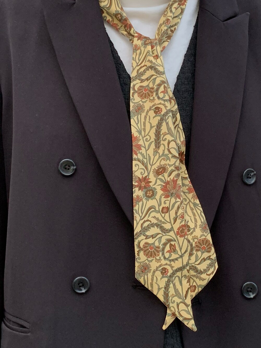 ブラック系のテーラードジャケット、イエロー系のバンダナ/スカーフを着用したレディースの冬コーディネートの2枚目の写真