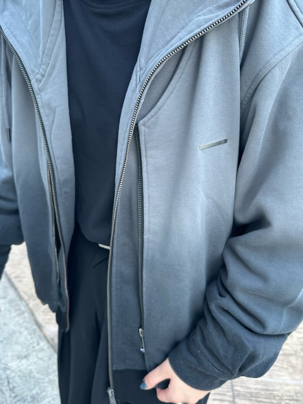 ブラック系のパーカーを着用したレディースの秋コーディネートの2枚目の写真