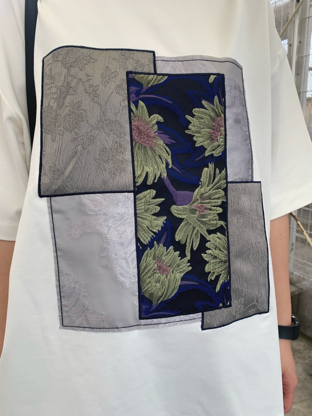 ホワイト系のTシャツ/カットソー、グレー系のデニムパンツ、ブラック系のショルダーバッグを着用したレディースの春コーディネートの2枚目の写真