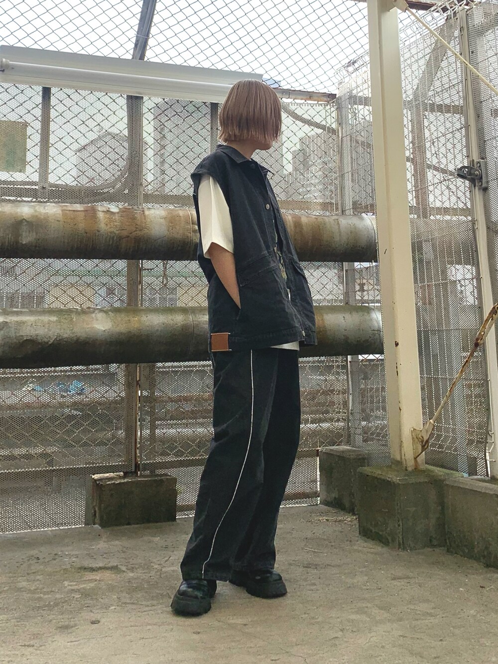 グレー系のデニムパンツ、グレー系のベスト、ホワイト系のTシャツ/カットソーを着用したレディースの春コーディネートの2枚目の写真