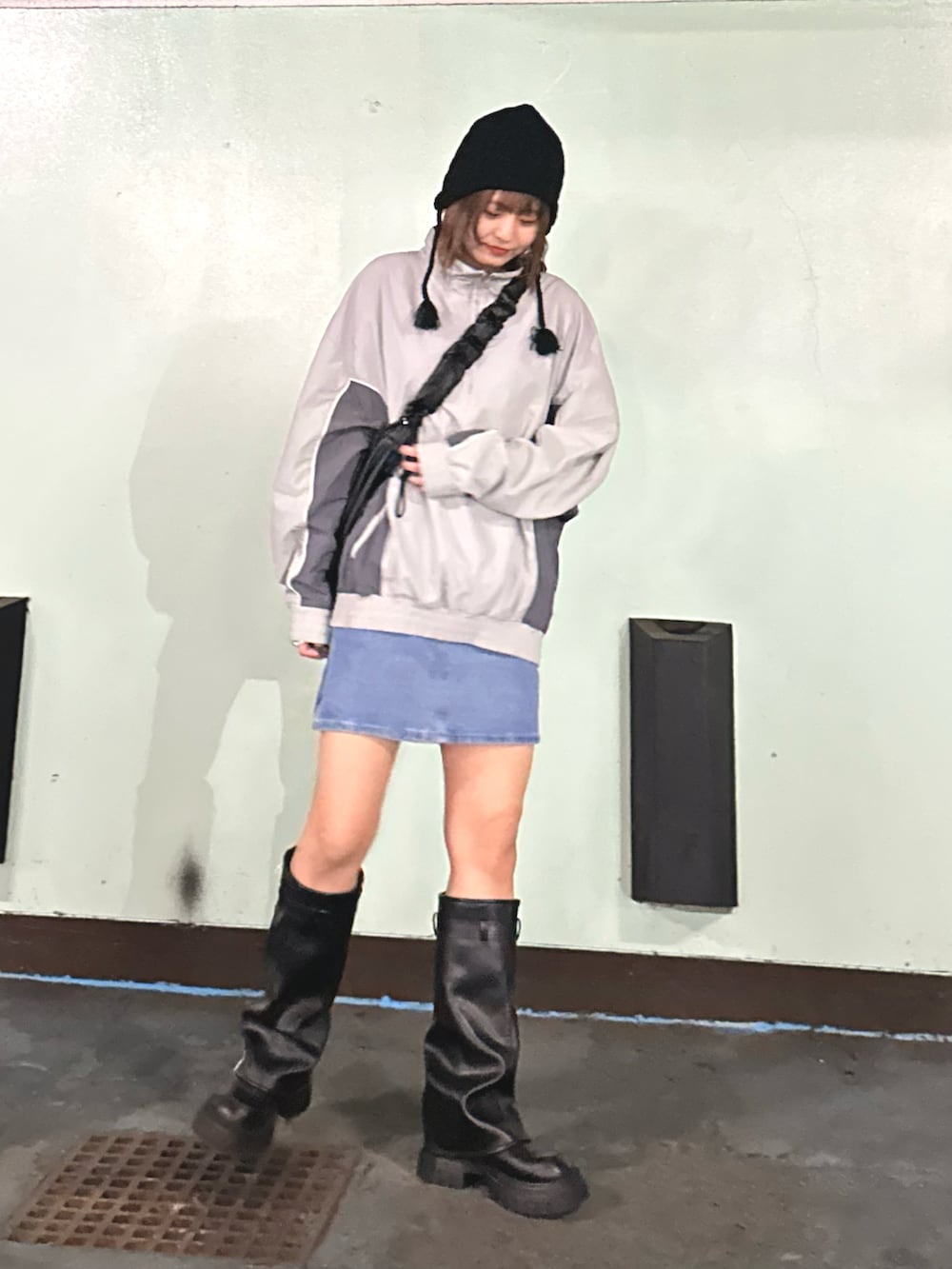 グレー系のブルゾン、ブラック系のショルダーバッグを着用したレディースの冬コーディネートの2枚目の写真