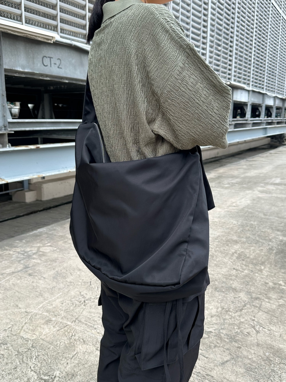 グリーン系のポロシャツ、ブラック系のその他パンツ、ブラック系のショルダーバッグを着用したレディースの夏コーディネートの2枚目の写真