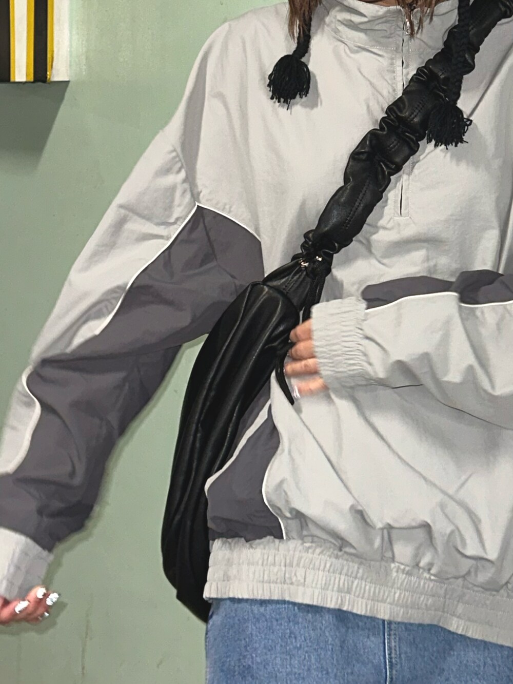 グレー系のブルゾン、ブラック系のショルダーバッグを着用したレディースの冬コーディネートの3枚目の写真