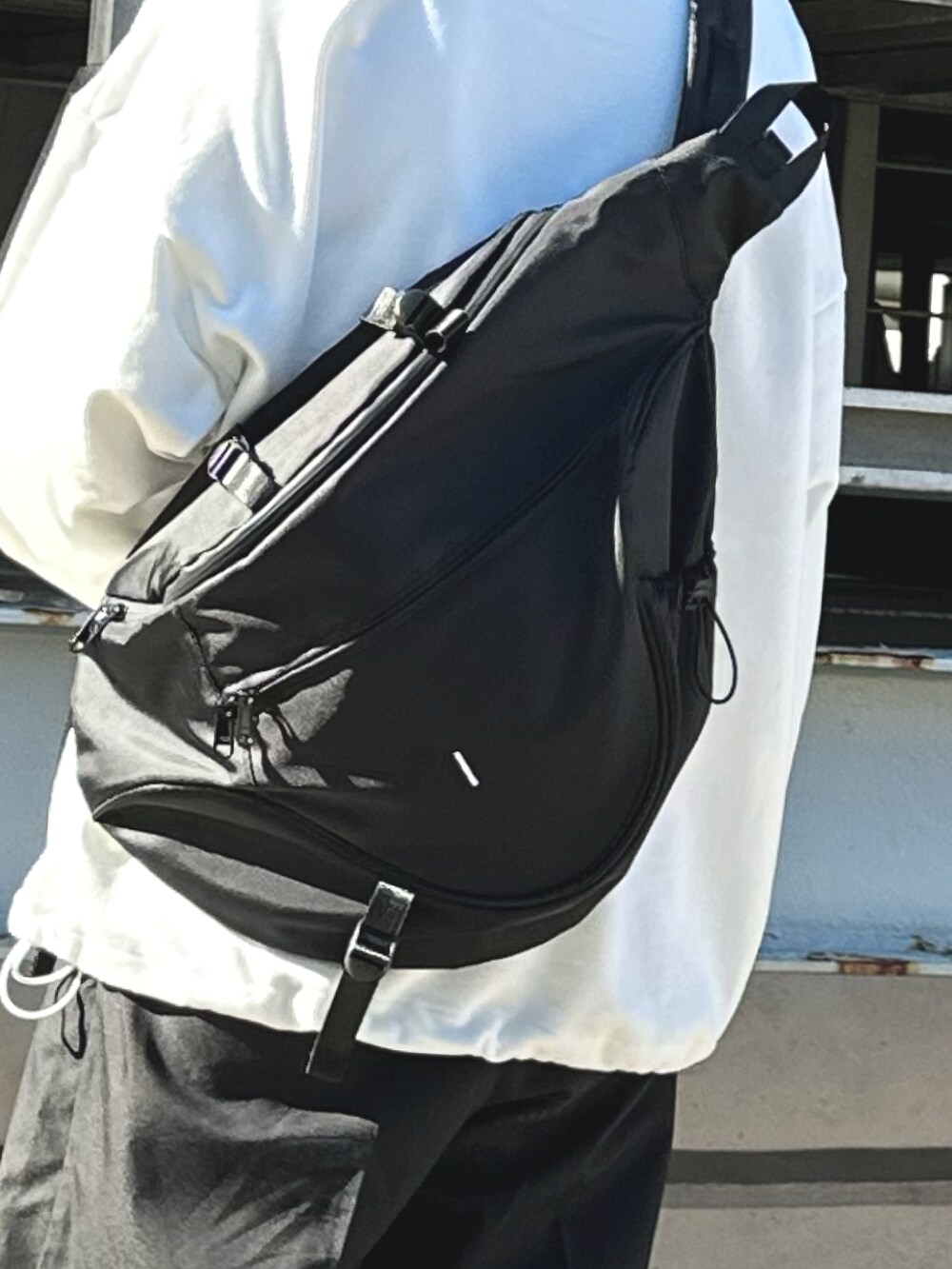 ホワイト系のスウェット、ブラック系のボディバッグ/ウエストポーチを着用したレディースの冬コーディネートの4枚目の写真