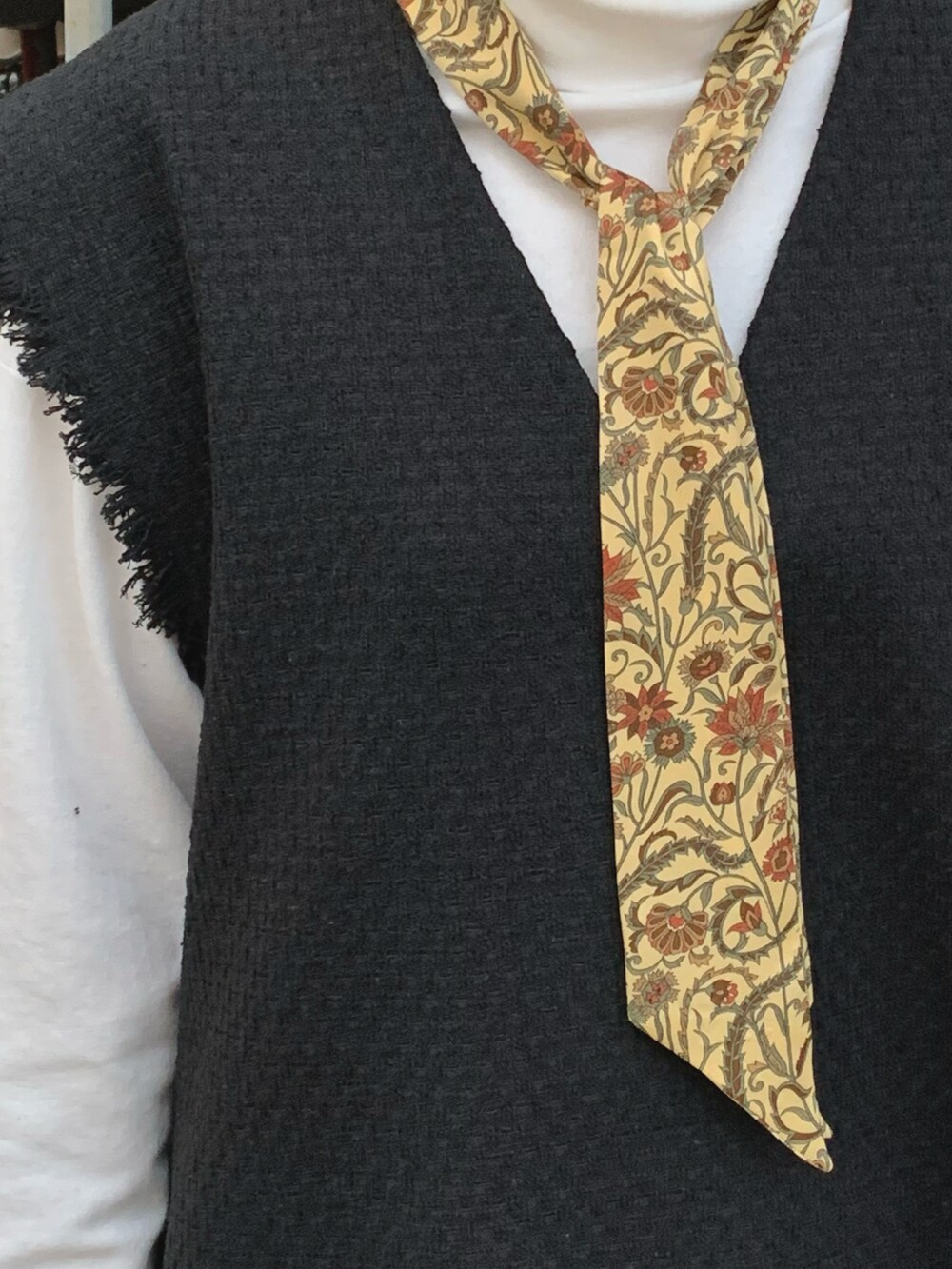 ブラック系のベスト、イエロー系のバンダナ/スカーフを着用したレディースの冬コーディネートの2枚目の写真