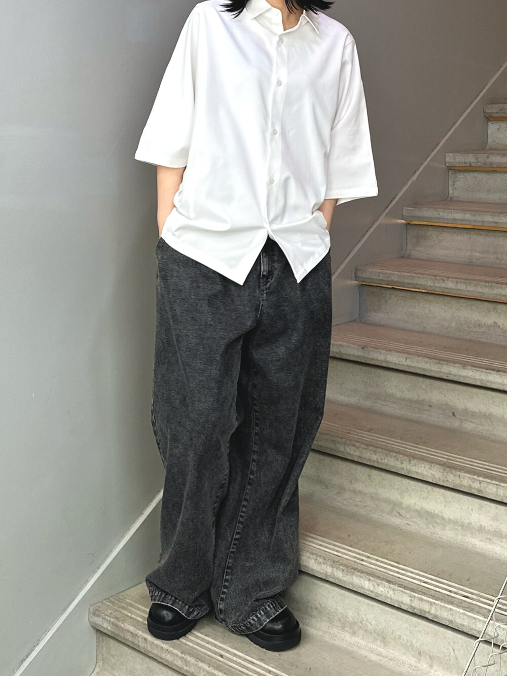 ブラック系のデニムパンツ、ホワイト系のシャツ/ブラウスを着用したレディースの春コーディネートの2枚目の写真