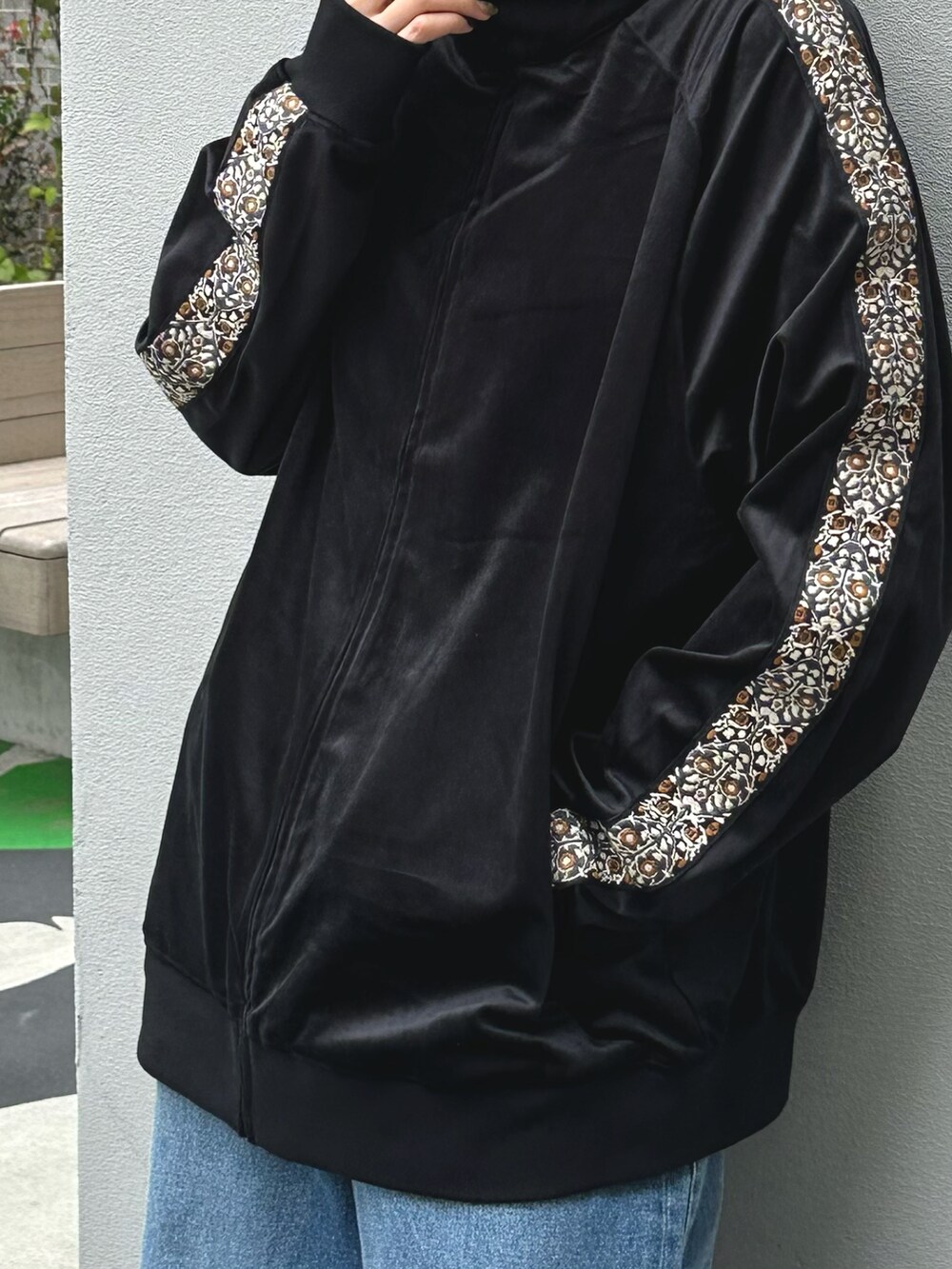 ブルー系のデニムパンツ、ブラック系のブルゾンを着用したレディースの秋コーディネートの2枚目の写真