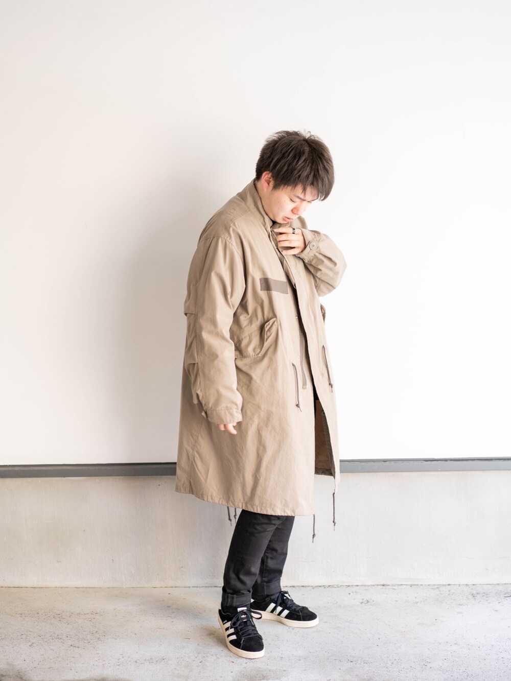 ベージュ系のその他アウター、ブラック系のその他パンツ、ブラック系のニット/セーターを着用したメンズの春コーディネートの2枚目の写真