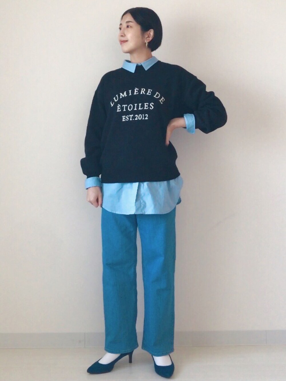 ブラック系のニット/セーター、ブルー系のシャツ/ブラウス、ブルー系のデニムパンツを着用したレディースの冬コーディネートの2枚目の写真