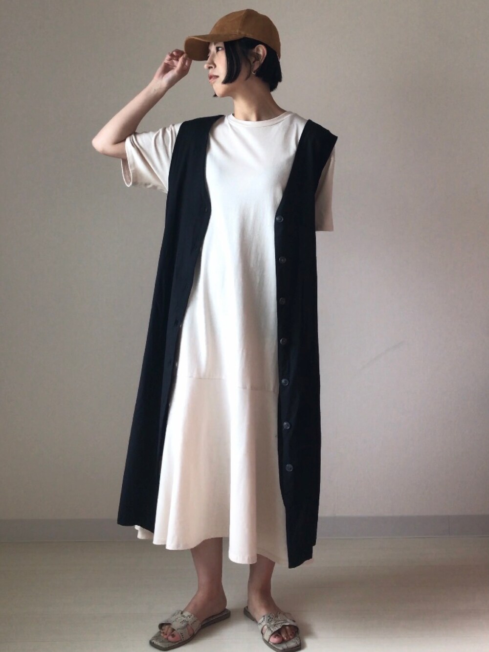 ホワイト系のワンピース、ブラック系のジャンパースカートを着用したレディースの夏コーディネートの3枚目の写真