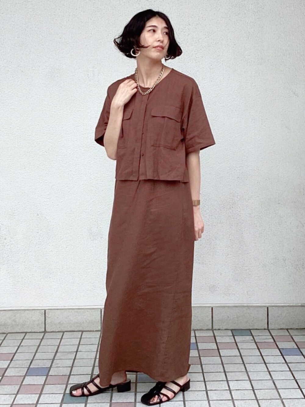ブラウン系のワンピース、ブラウン系のノーカラージャケット、ブラック系のサンダルを着用したレディースの夏コーディネートの2枚目の写真