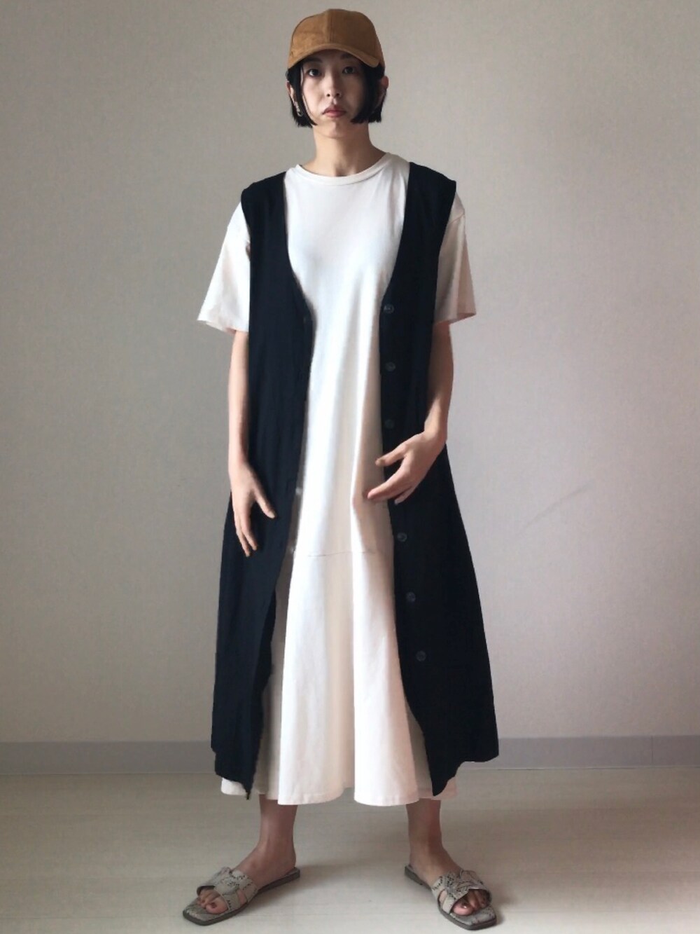 ホワイト系のワンピース、ブラック系のジャンパースカートを着用したレディースの夏コーディネートの4枚目の写真