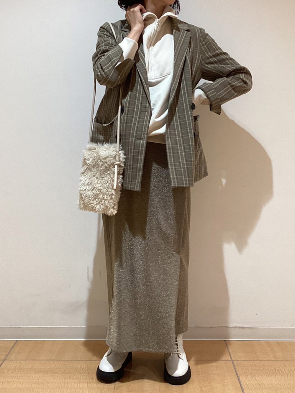 グレー系のノーカラージャケット、ホワイト系のブーツ、ホワイト系のTシャツ/カットソーを着用したレディースの秋コーディネートの3枚目の写真