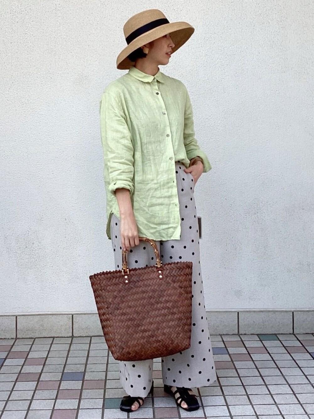 グリーン系のシャツ/ブラウス、ブラウン系のハンドバッグ、ブラック系のサンダルを着用したレディースの春コーディネートの2枚目の写真