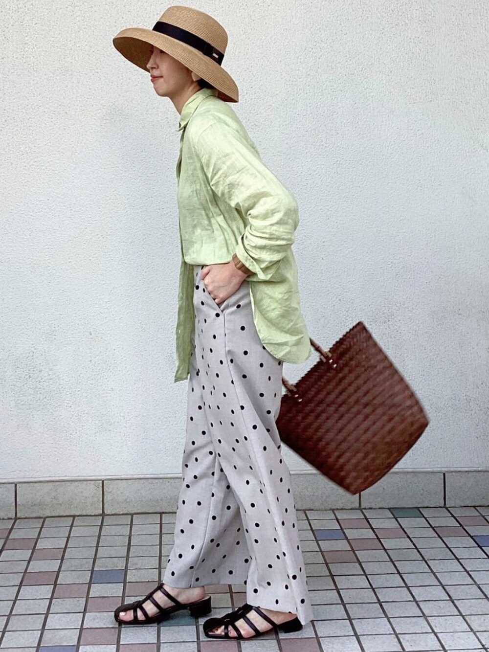 グリーン系のシャツ/ブラウス、ブラウン系のハンドバッグ、ブラック系のサンダルを着用したレディースの春コーディネートの3枚目の写真