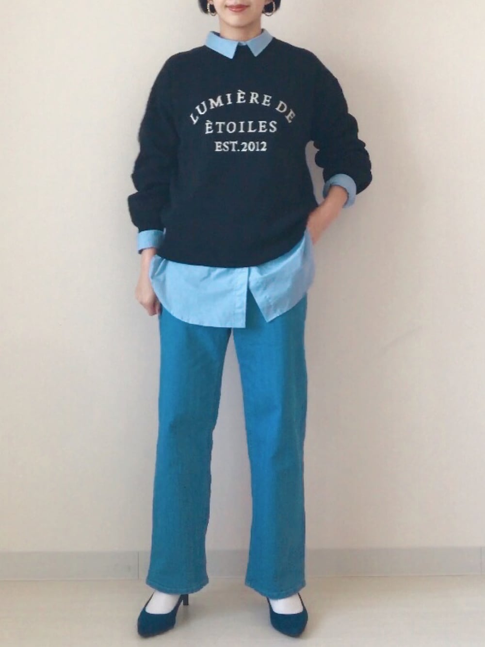 ブラック系のニット/セーター、ブルー系のシャツ/ブラウス、ブルー系のデニムパンツを着用したレディースの冬コーディネートの3枚目の写真