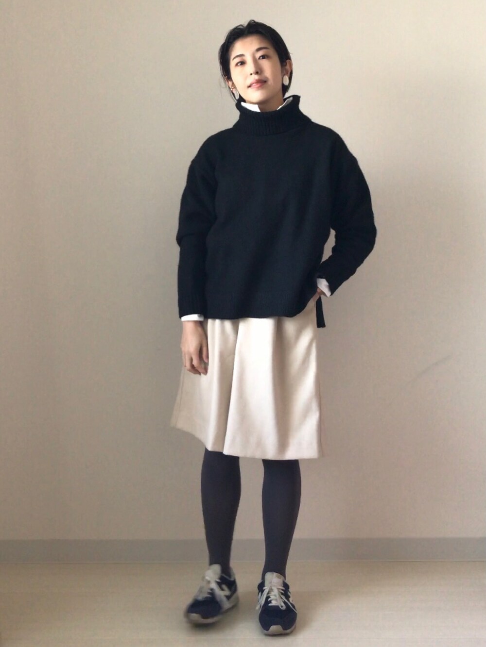 ブラック系のニット/セーター、ホワイト系のシャツ/ブラウス、ベージュ系のその他パンツを着用したレディースの冬コーディネートの2枚目の写真