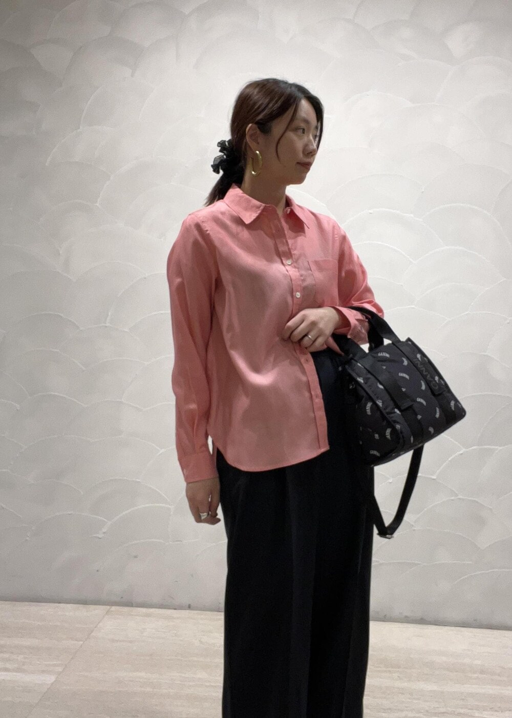 ブラック系のトートバッグ、ブルー系のスラックス、ピンク系のシャツ/ブラウスを着用したレディースの春コーディネートの3枚目の写真