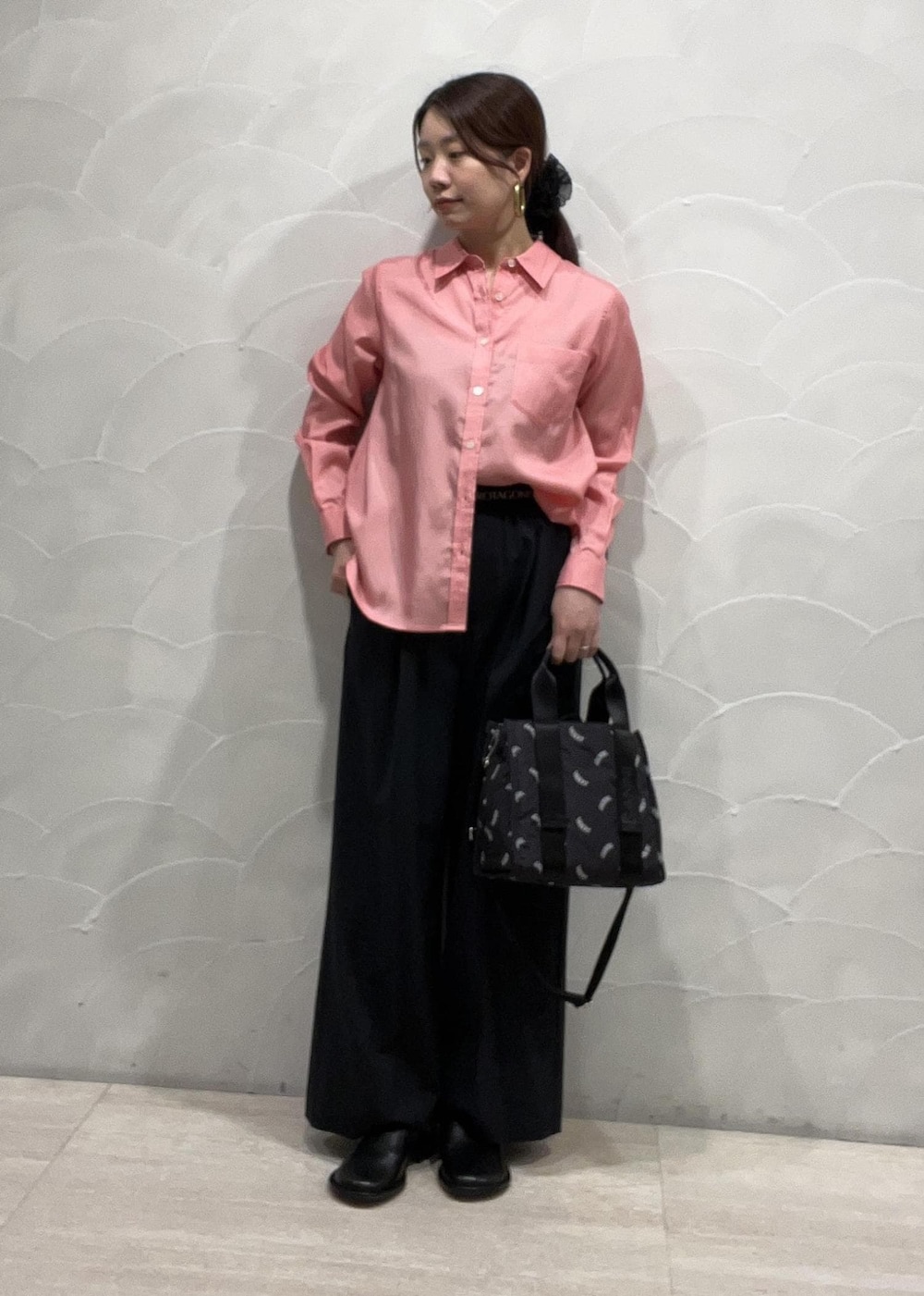 ブラック系のトートバッグ、ブルー系のスラックス、ピンク系のシャツ/ブラウスを着用したレディースの春コーディネートの2枚目の写真