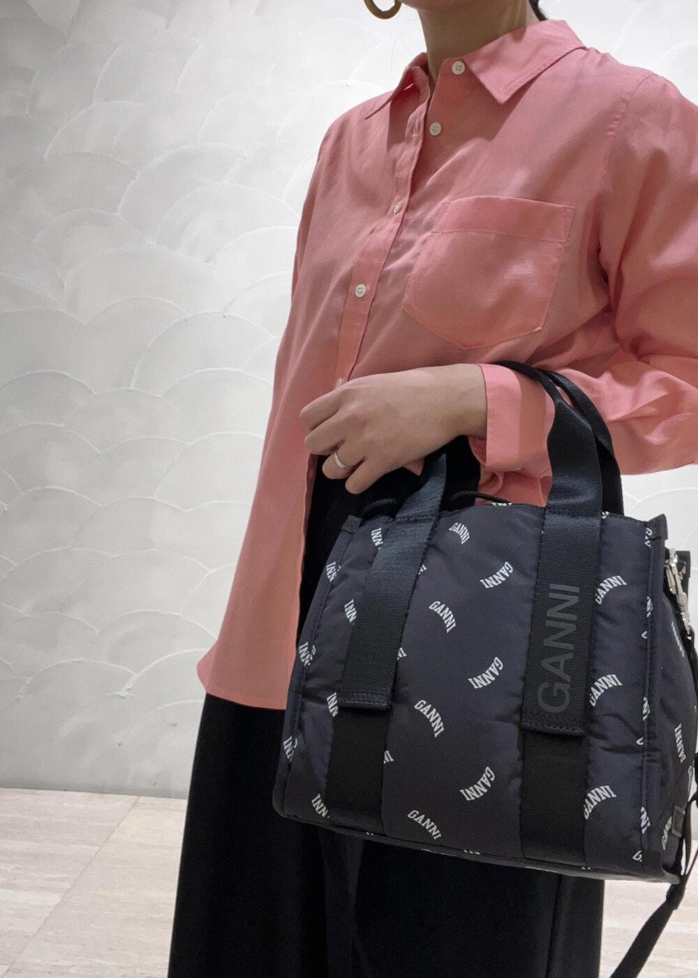 ブラック系のトートバッグ、ブルー系のスラックス、ピンク系のシャツ/ブラウスを着用したレディースの春コーディネートの5枚目の写真