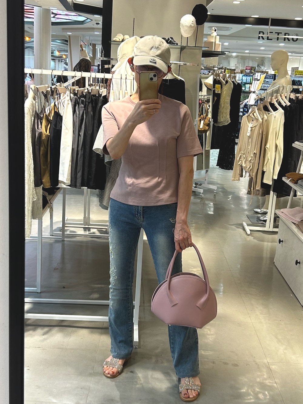 ピンク系のショルダーバッグ、ゴールド系のサンダル、ピンク系のTシャツ/カットソーを着用したレディースの秋コーディネートの2枚目の写真