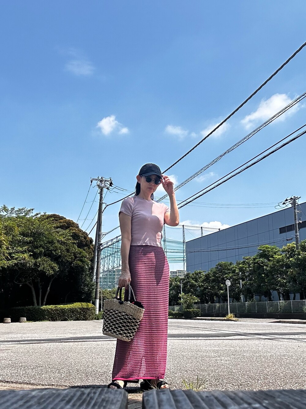 ピンク系のTシャツ/カットソー、その他のかごバッグ、ピンク系のスカートを着用したレディースの夏コーディネートの2枚目の写真